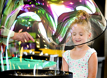 girl looking at a large bubble